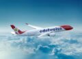 EDELWIESS - The Brief | Namibia's Leading Business & Financial News White and red Edelweiss airliner in flight above fluffy clouds, blue sky background, logo on the fuselage.