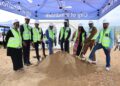 WhatsApp Image 2026-04-30 at 40218 PM - The Brief | Namibia's Leading Business & Financial News Group of officials in hard hats and neon vests shovel dirt at a ground-breaking ceremony under a blue canopy.