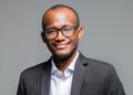 Jesaya Hano-Oshike - The Brief | Namibia's Leading Business & Financial News Professional headshot of a man wearing a dark suit and glasses, smiling at the camera.