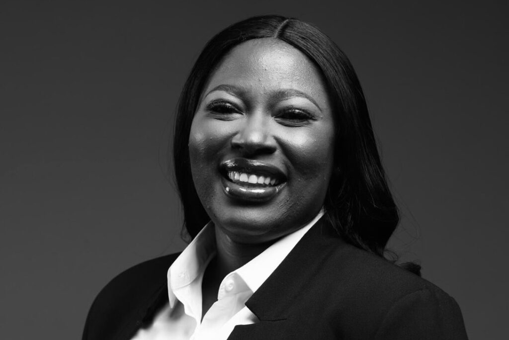 Maria Samahina - The Brief | Namibia's Leading Business & Financial News Smiling Black woman in a white collared shirt and dark blazer, looking at the camera.