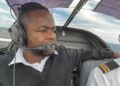 Clerence Kameeta - The Brief | Namibia's Leading Business & Financial News Male pilot wearing a headset and microphone in a small aircraft cockpit, looking focused at the horizon through the canopy.