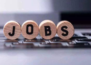 Wooden letter blocks spell 'JOBS' resting on a laptop keyboard.