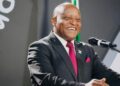 WhatsApp Image 2026-05-21 at 45446 PM - The Brief | Namibia's Leading Business & Financial News Smiling man in a dark suit and red tie speaking at a microphone on stage.