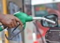 FUEL4 - The Brief | Namibia's Leading Business & Financial News Close-up of a person fueling a car with a green gas pump nozzle at the fuel cap.