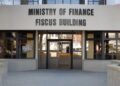 Finance Ministry - The Brief | Namibia's Leading Business & Financial News Front entrance of the Ministry of Finance, with a large sign reading 'MINISTRY OF FINANCE FISCUS BUILDING' above glass doors.