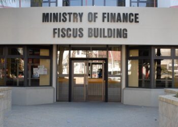 Finance Ministry - The Brief | Namibia's Leading Business & Financial News Front entrance of the Ministry of Finance, with a large sign reading 'MINISTRY OF FINANCE FISCUS BUILDING' above glass doors.