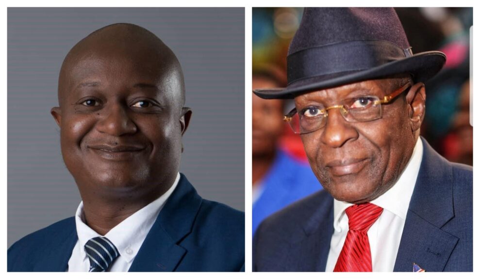 Two men in formal suits side by side: left is a smiling young man in a navy suit; right is an older man in a suit with a red tie and hat at a formal event.