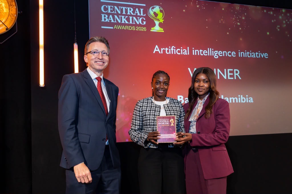 Three people on stage at Central Banking Awards 2026; the winner holds a plaque in front of a red backdrop.