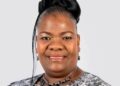 Evelyn Nawases-Taeyele - The Brief | Namibia's Leading Business & Financial News Smiling woman in a patterned blouse with a black necklace, against a light gray backdrop (formal portrait)