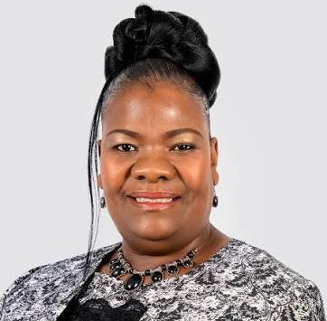Evelyn Nawases-Taeyele - The Brief | Namibia's Leading Business & Financial News Smiling woman in a patterned blouse with a black necklace, against a light gray backdrop (formal portrait)