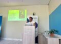 WhatsApp Image 2026-06-18 at 55252 PM - The Brief | Namibia's Leading Business & Financial News Speaker at a podium labeled 'House of Democracy' giving a talk, with a projector slide on the wall and an IPPR banner behind.