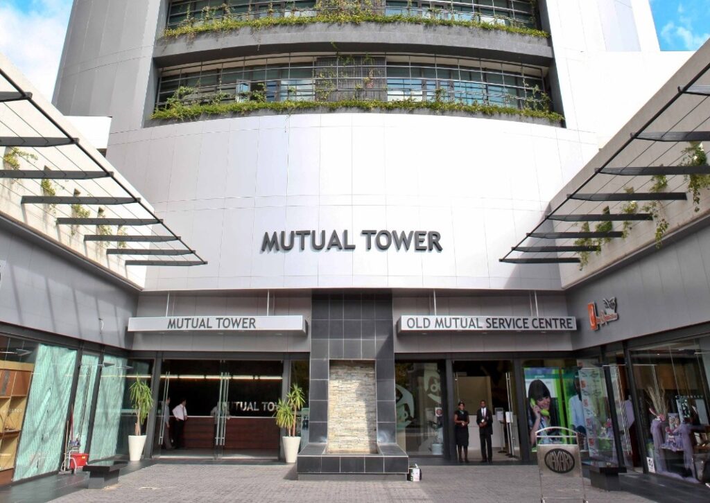 OLD MUTUAL TOWER - The Brief | Namibia's Leading Business & Financial News Facade of Mutual Tower building with signage reading Mutual Tower and Old Mutual Service Centre, glass doors, and people near entrance.
