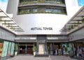 OLD MUTUAL TOWER - The Brief | Namibia's Leading Business & Financial News Facade of Mutual Tower building with signage reading Mutual Tower and Old Mutual Service Centre, glass doors, and people near entrance.