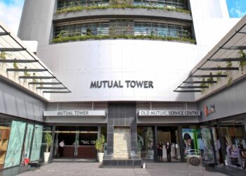 OLD MUTUAL TOWER - The Brief | Namibia's Leading Business & Financial News Facade of Mutual Tower building with signage reading Mutual Tower and Old Mutual Service Centre, glass doors, and people near entrance.