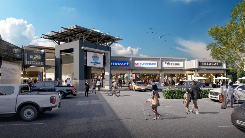 Goreangab Mall - The Brief | Namibia's Leading Business & Financial News A sunny outdoor shopping plaza with a central entrance, storefronts, and people walking or cycling near parked cars.