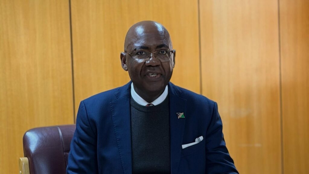 I-Ben Natangwe Nashandi - The Brief | Namibia's Leading Business & Financial News Man in a navy blazer with a white pocket square, seated in a wood-paneled office.
