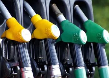Gas pumps with yellow and green nozzles at a fuel station.
