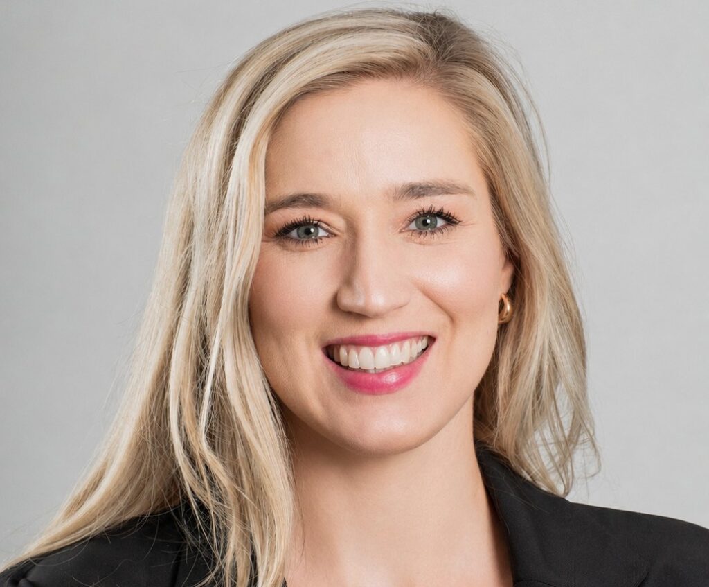 Zandria Venter - The Brief | Namibia's Leading Business & Financial News Smiling woman with long blonde hair wearing a black blazer against a gray background (professional headshot).