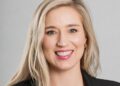 Zandria Venter - The Brief | Namibia's Leading Business & Financial News Smiling woman with long blonde hair wearing a black blazer against a gray background (professional headshot).