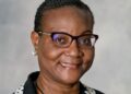 Nangula Hamunyela - The Brief | Namibia's Leading Business & Financial News Smiling Black woman wearing glasses and a black blazer with a white polka-dotted collar.
