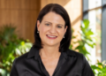 Marlize Horn Capricorn Foundation - The Brief | Namibia's Leading Business & Financial News Smiling woman in a black blouse stands in a bright, plant-filled office background.
