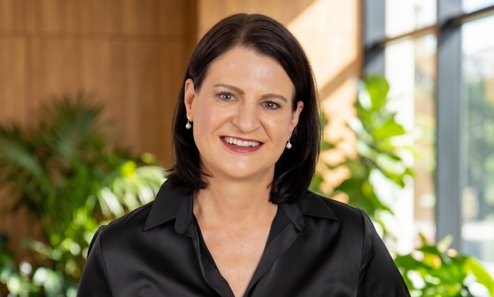 Marlize Horn Capricorn Foundation - The Brief | Namibia's Leading Business & Financial News Smiling woman in a black blouse stands in a bright, plant-filled office background.