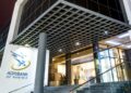 Exterior view of Agribank Namibia storefront with glass doors and blue logo on white wall under a grid-pattern overhang