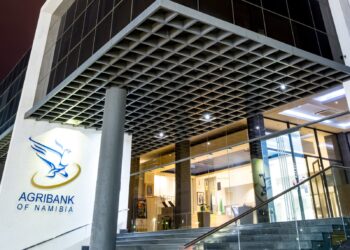 AGRIBANK - The Brief | Namibia's Leading Business & Financial News Exterior view of Agribank Namibia storefront with glass doors and blue logo on white wall under a grid-pattern overhang