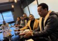 WhatsApp Image 2026-07-14 at 34549 PM - The Brief | Namibia's Leading Business & Financial News Seven people sit around a conference table in a meeting, with one man in a black shearling jacket closest to the camera.
