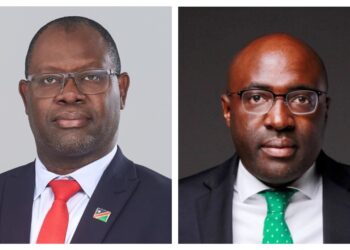 Pair of formal headshots: man on the left in a dark suit with a red tie and lapel pin against a gray backdrop; man on the right in a dark suit with a green tie against a dark background.