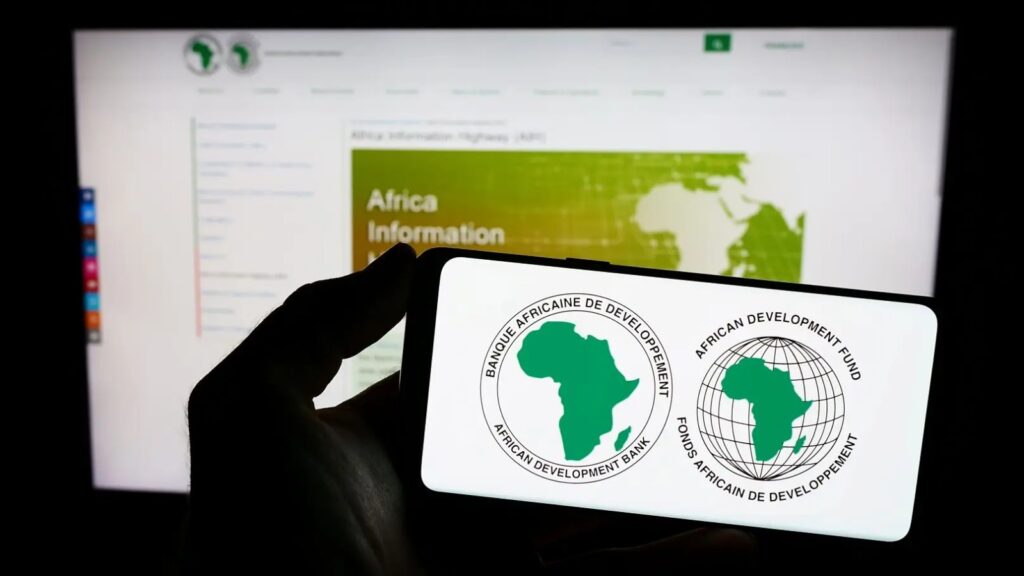 AFDB2 - The Brief | Namibia's Leading Business & Financial News Smartphone screen showing the African Development Bank and African Development Fund logos against a blurred computer screen in the background.