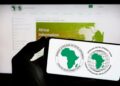 AFDB2 - The Brief | Namibia's Leading Business & Financial News Smartphone screen showing the African Development Bank and African Development Fund logos against a blurred computer screen in the background.