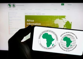 Smartphone screen showing the African Development Bank and African Development Fund logos against a blurred computer screen in the background.