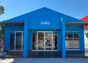 Blue MT C storefront with a peaked roof, glass doors, and 'make the connection' logo above the entrance.
