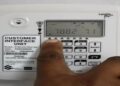 ELECTRICITY5 - The Brief | Namibia's Leading Business & Financial News Close-up of a white Customer Interface Unit with a numeric keypad; a finger presses a key while the display shows numbers.