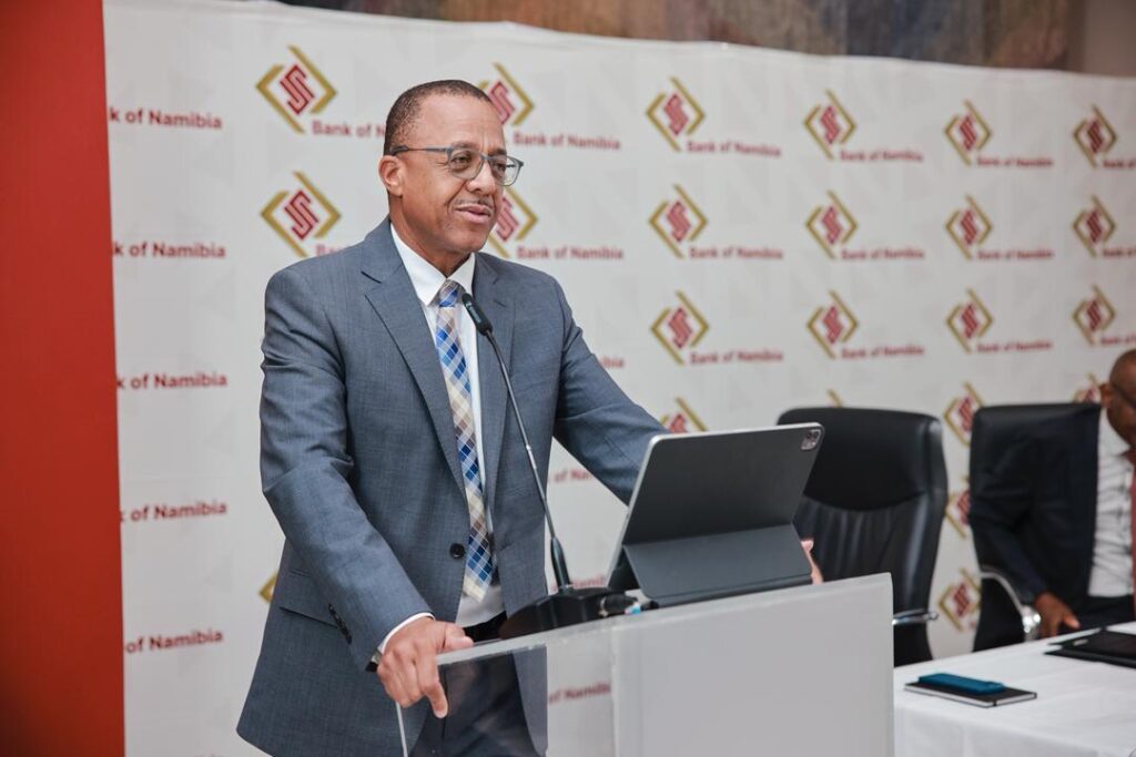 EBSON01 - The Brief | Namibia's Leading Business & Financial News Man in a gray suit delivers a speech at a podium, with a Bank of Namibia backdrop behind him.