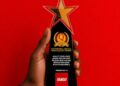 Trophy held in a hand against a red background, text reads 'Started from the bottom, now we're platinum' with YANGO as Platinum Winner 2026.