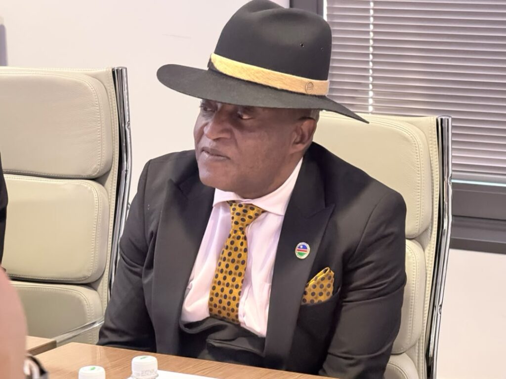 WhatsApp Image 2026-07-30 at 43553 PM - The Brief | Namibia's Leading Business & Financial News Man in a black suit with a yellow polka-dot tie and fedora, seated at a conference table and looking to the side.
