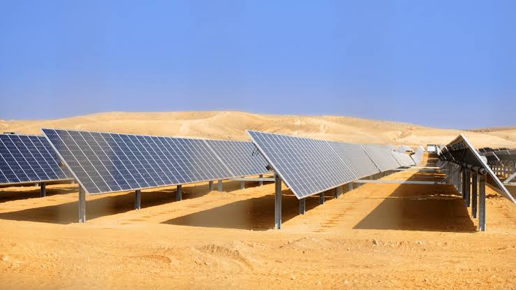 solar energy - The Brief | Namibia's Leading Business & Financial News Solar panels installed in a desert landscape, arranged in rows under a clear blue sky for photovoltaic energy generation.