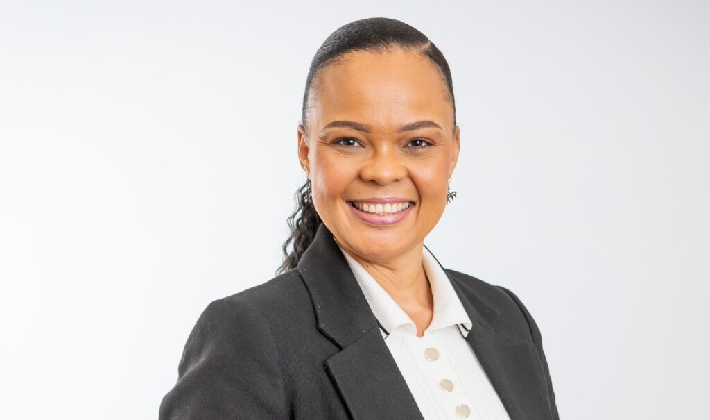 Isobel Manuel - The Brief | Namibia's Leading Business & Financial News Smiling woman in a dark blazer and white blouse against a light studio background.