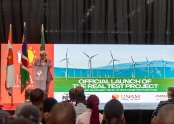 WhatsApp Image 2026-08-11 at 95538 AM - The Brief | Namibia's Leading Business & Financial News Speaker at a podium giving a speech at an official launch event, with flags and a banner that reads 'Official Launch of the Real Test Project' behind her.