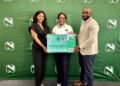 Three people pose with a large Nedbank Go Green debit card prop in front of a green backdrop featuring white logos, smiling for the photo.
