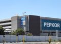 Exterior view of a large gray commercial building with a prominent blue PEPKOR sign on the facade.