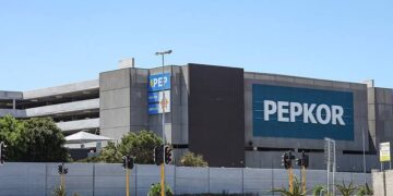 Exterior view of a large gray commercial building with a prominent blue PEPKOR sign on the facade.