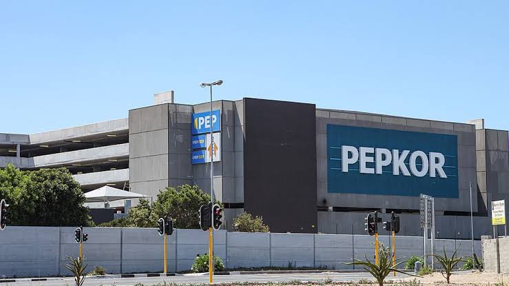 Exterior view of a large gray commercial building with a prominent blue PEPKOR sign on the facade.