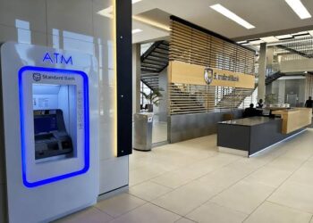 STANDARD BANK ATM - The Brief | Namibia's Leading Business & Financial News Indoor Standard Bank lobby with a blue-lit ATM on the left and a service desk visible in the background.