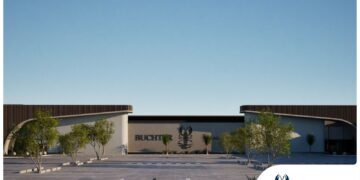 Exterior view of Buchter Mall with modern curved entrances, palm trees, and a clear blue sky; parking lot in foreground.