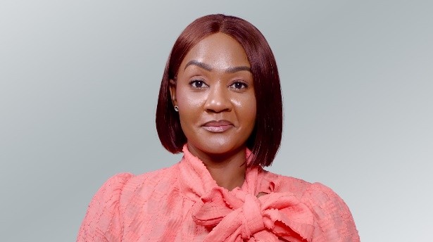 Sara Mezui Engo - The Brief | Namibia's Leading Business & Financial News Portrait of a woman with a burgundy bob, wearing a pink blouse with a bow, smiling at the camera.
