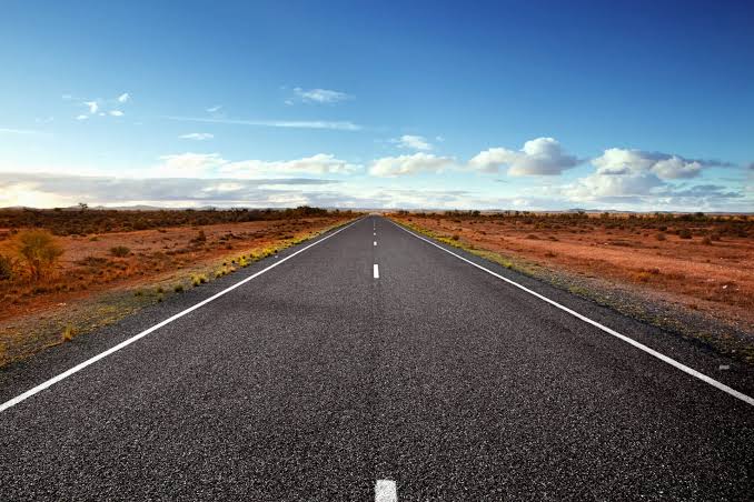 ROAD1 - The Brief | Namibia's Leading Business & Financial News Straight highway through a desert landscape under a blue sky with a few clouds.