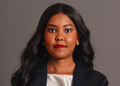 Nangula Iithete1 - The Brief | Namibia's Leading Business & Financial News Portrait of a woman with long black hair, wearing a black blazer and white top, looking at the camera on a gray studio backdrop